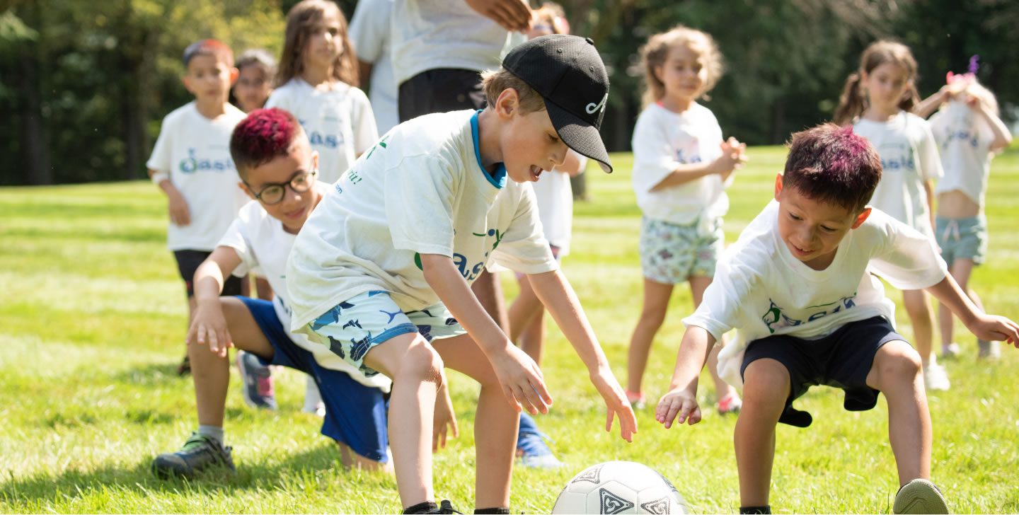 two campers grabbing soccer ball