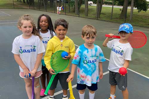 Campers posing with tennis rackets