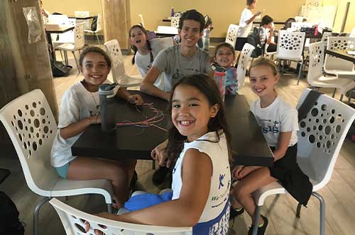 campers smiling at a table