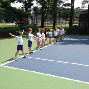kids on a line on a tennis court