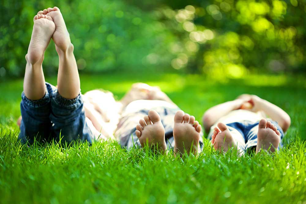 three children laying in the grass